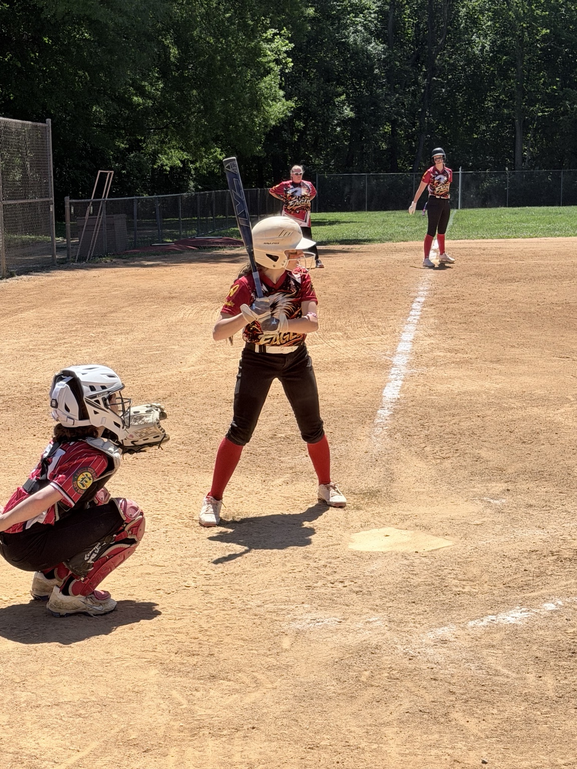 Lady Eagles batter set at the plate with the catcher ready