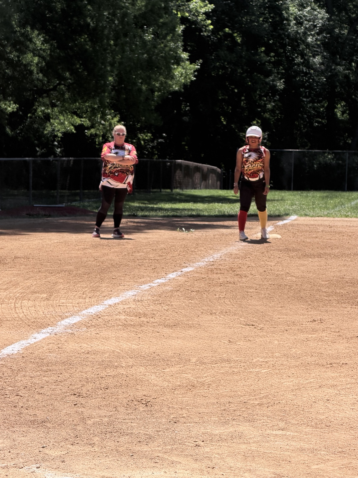 Lady Eagles coach beside a runner on base