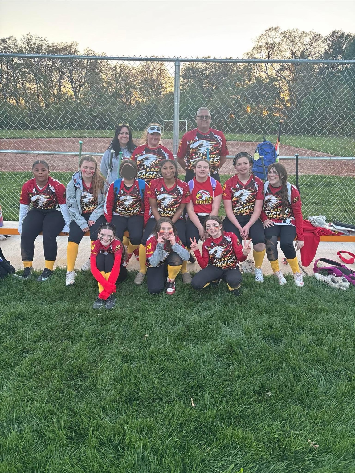 Lady Eagles team gathered beside the softball field